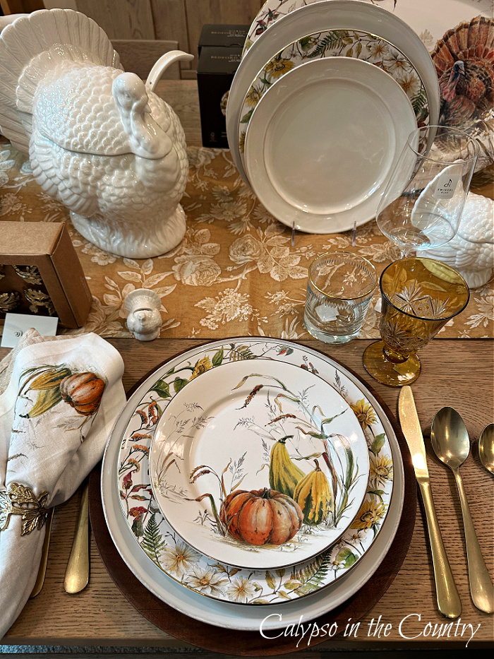 Pumpkin plates, white turkey decor and gold patterned table runner - cozy up your home for fall