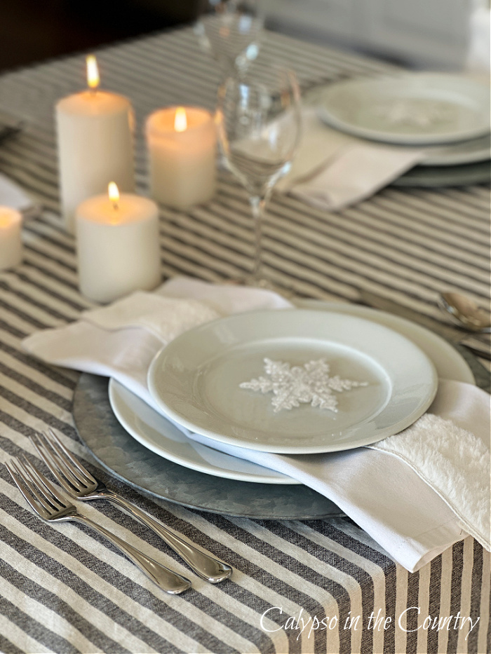 White plates and napkins with snowflake and candles - winter white table setting