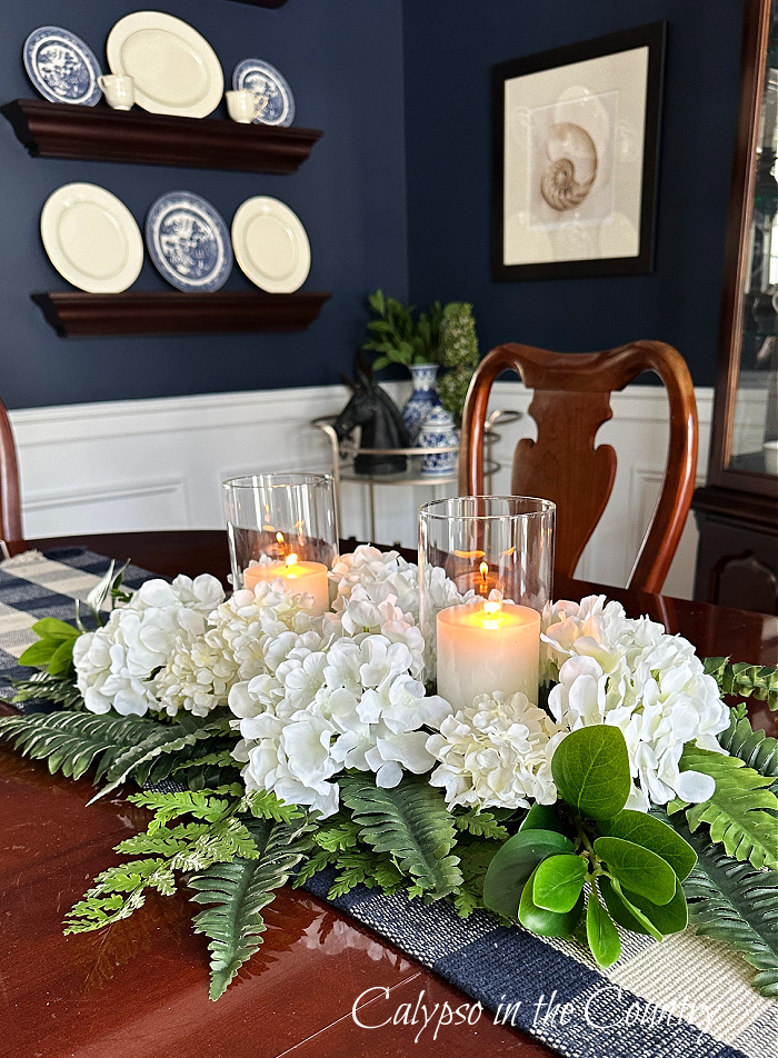 centerpiece with ferns, white hydrangeas and candles on dining room table - fern decorating ideas 