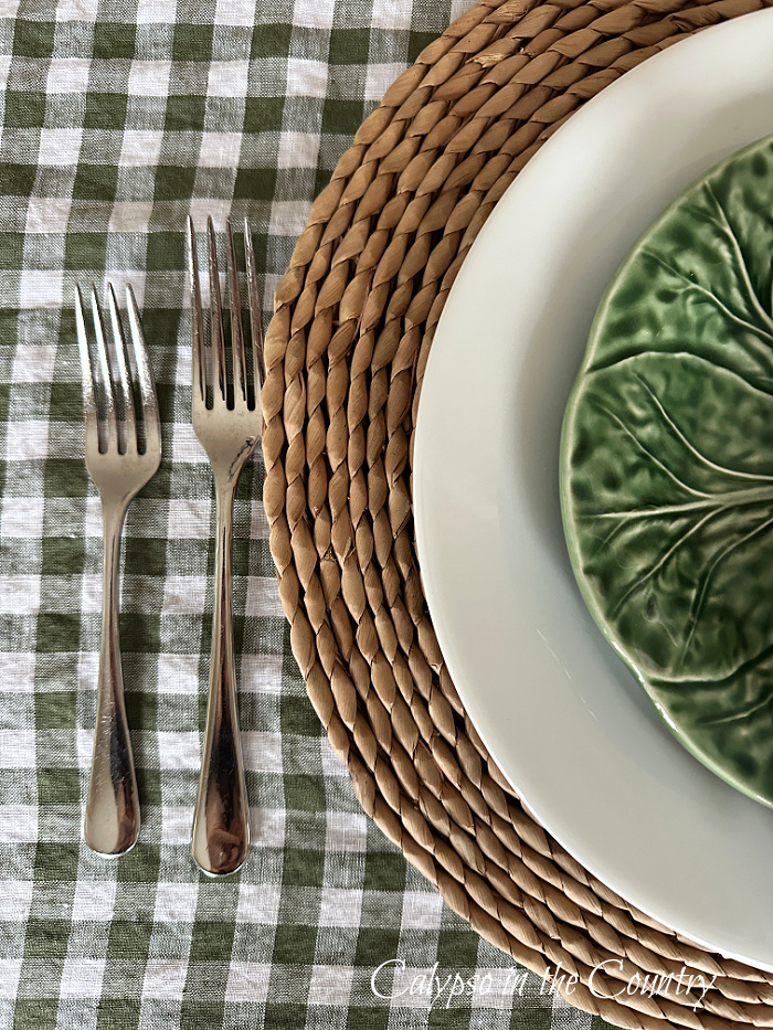 Green checked tablecloth, forks, seagrass charger, white plate and green salad plate - simple Easter brunch table setting