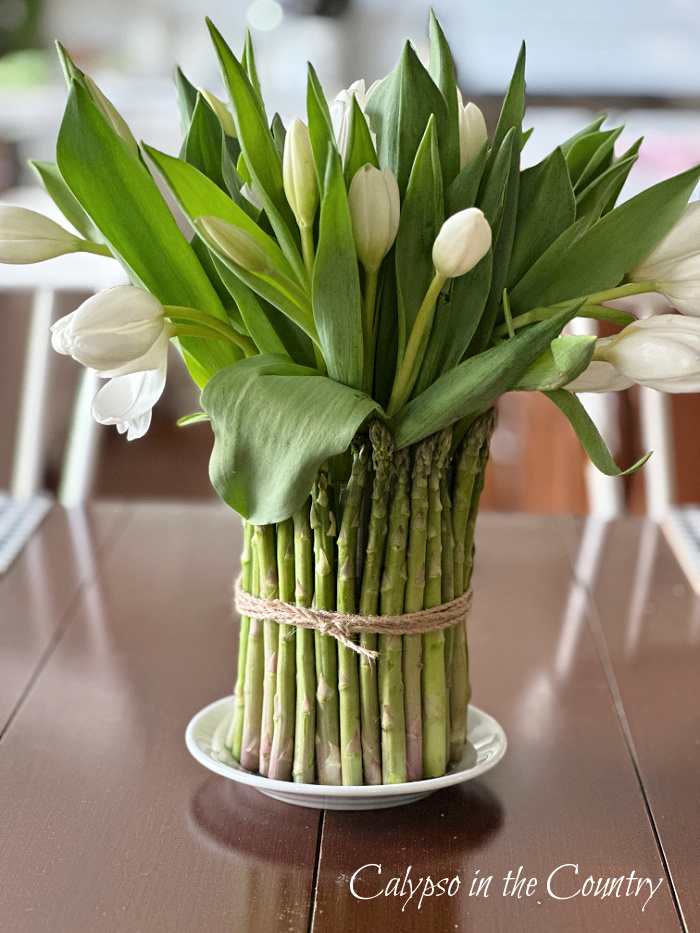 asparagus vase with tulips on kitchen table