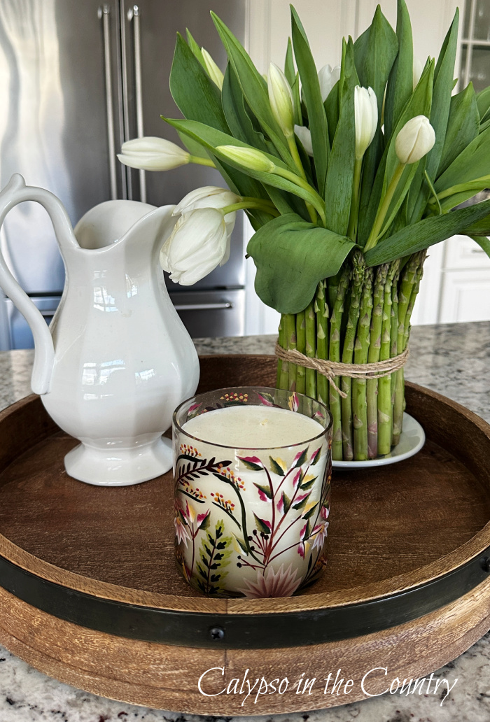 DIY asparagus vase with white pitcher and candle on round tray