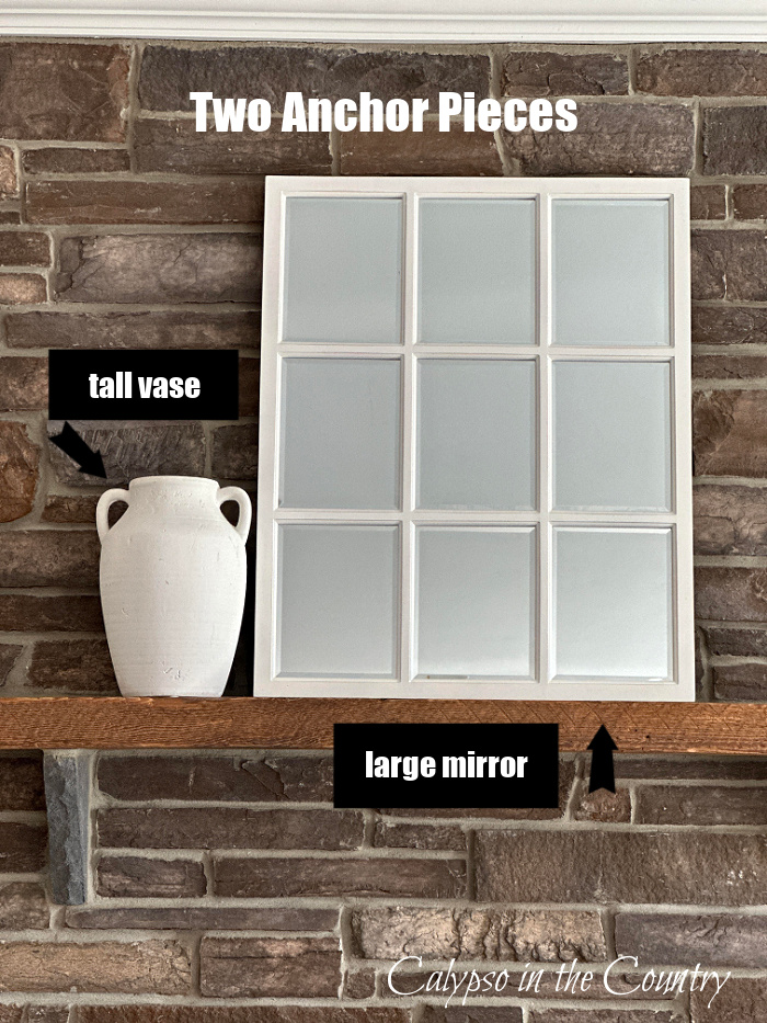 White vase and white window pane mirror set on mantel of stone fireplace - decorate a mantel for every season