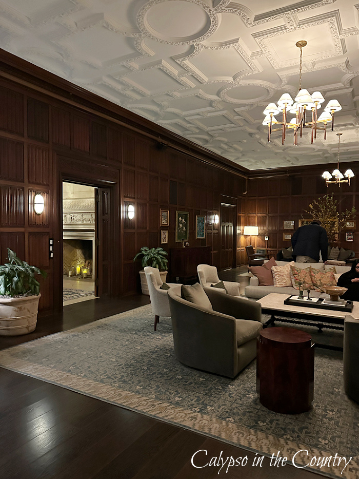 Lounge area with wood paneled walls and white ceiling with moldings - March wrap up