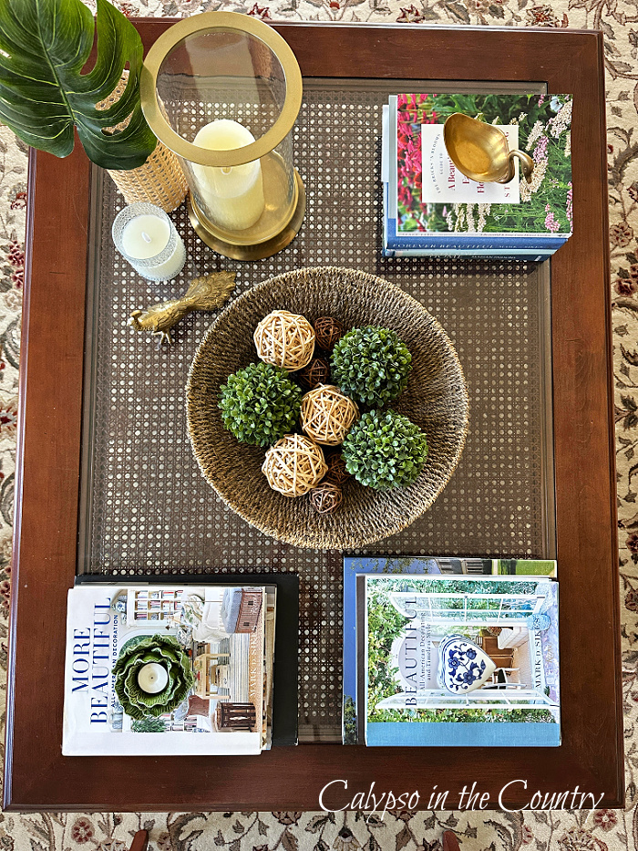 Top view of coffee table decorated for spring with greenery, candles and stacks of books - March wrap up