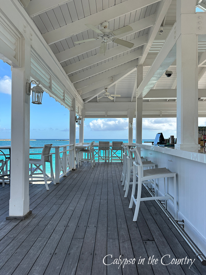 Beach bar with white vaulted ceiling and turquoise water in background