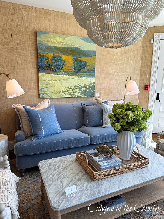 Blue sofa under painting with coastal lighting and coffee table - April wrap up