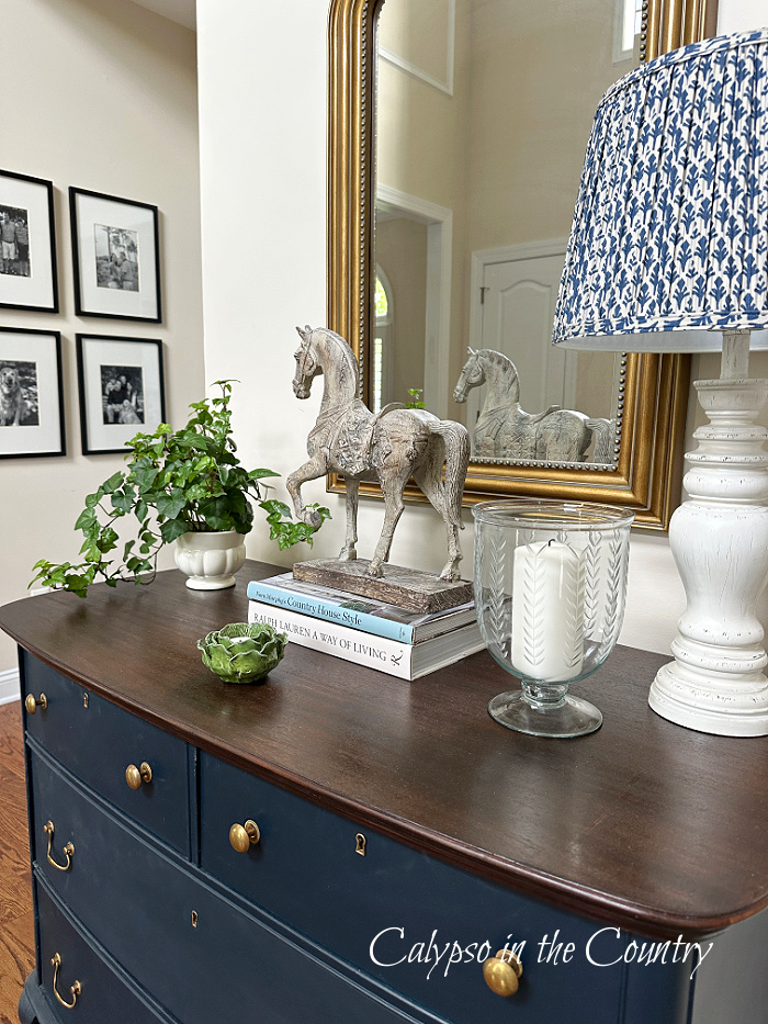 blue dresser decorated for spring with plant, candle and lamp -april wrap up