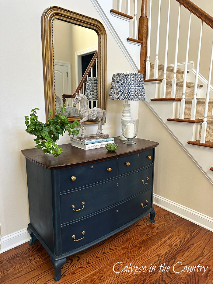 blue dresser in foyer decorated with lamp and plant - April wrap up