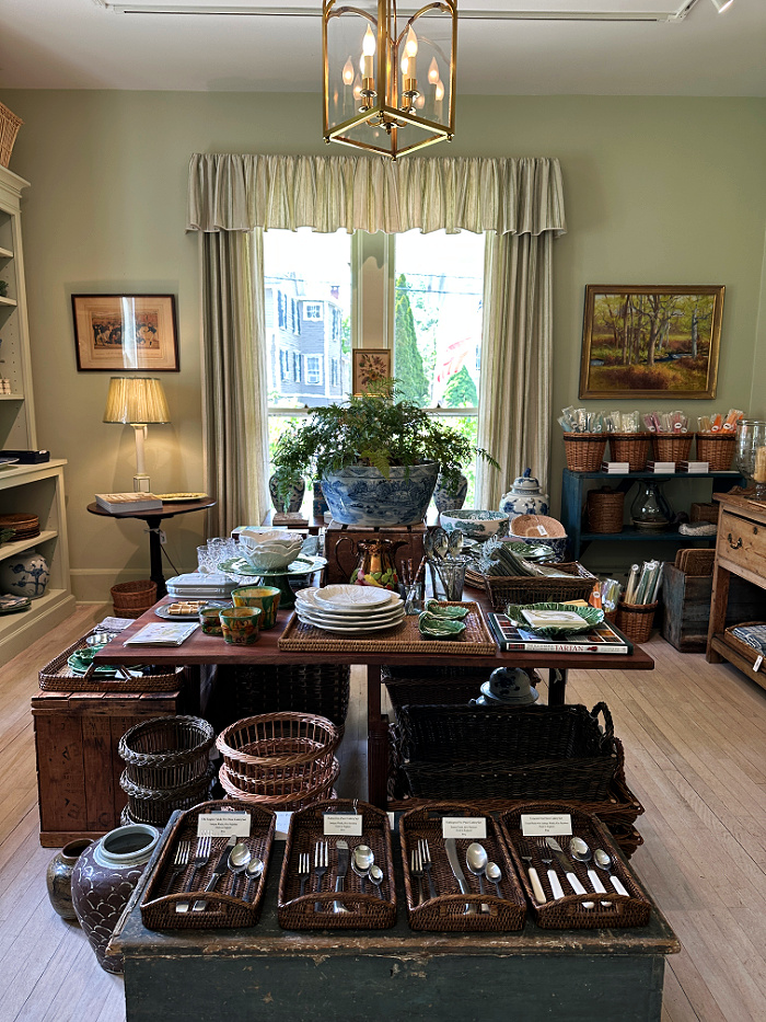 wood table displaying home decor items in store - welcome May