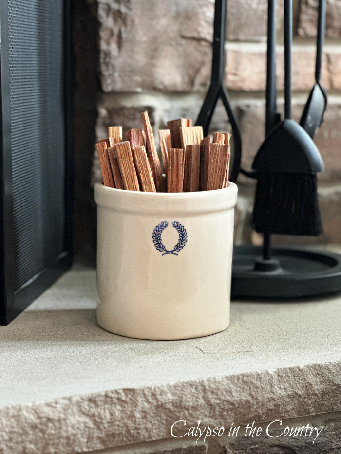 Ceramic crock filled with wood fire sticks on fireplace hearth - May Wrap Up