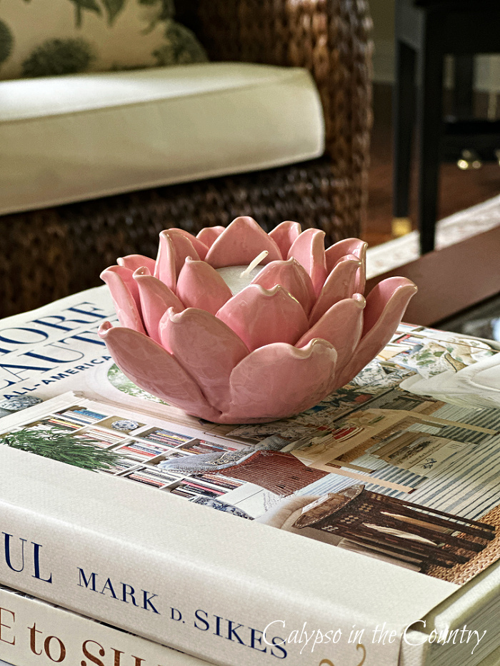 Pink ceramic flower candle holder on stack of books