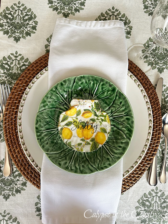 Place setting with green salad plate, white napkin and lemon patterned shell place card - How to decoupage shells with napkins