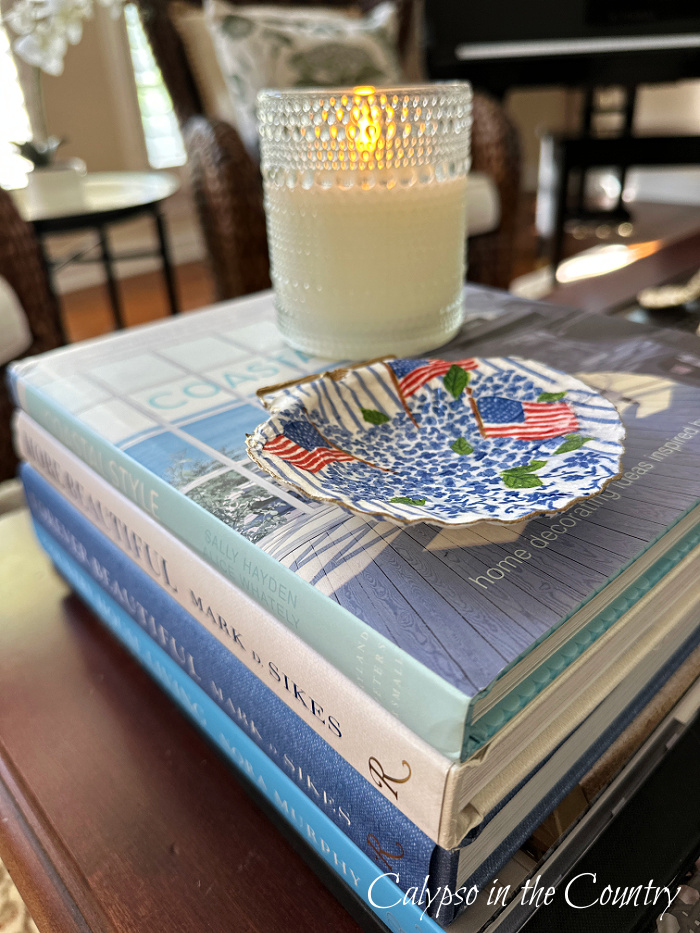 flag patterned shell on stack of coffee table books