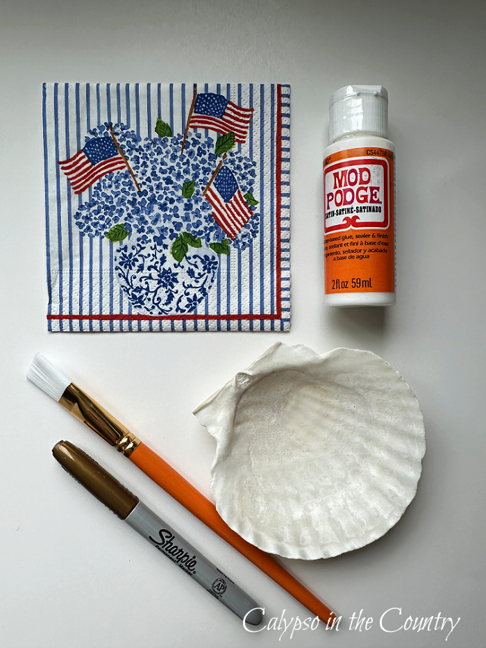 Flag napkin, Mod Podge, paint brush, sharpie and scallop shell - how to decoupage shells with napkins