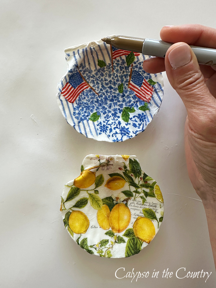 Hand applying gold sharpie trim to decoupaged shell