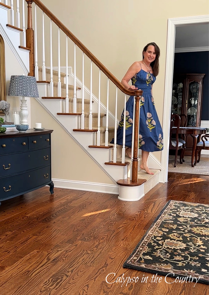 Woman walking down open staircase in blue block print dress - June wrap up