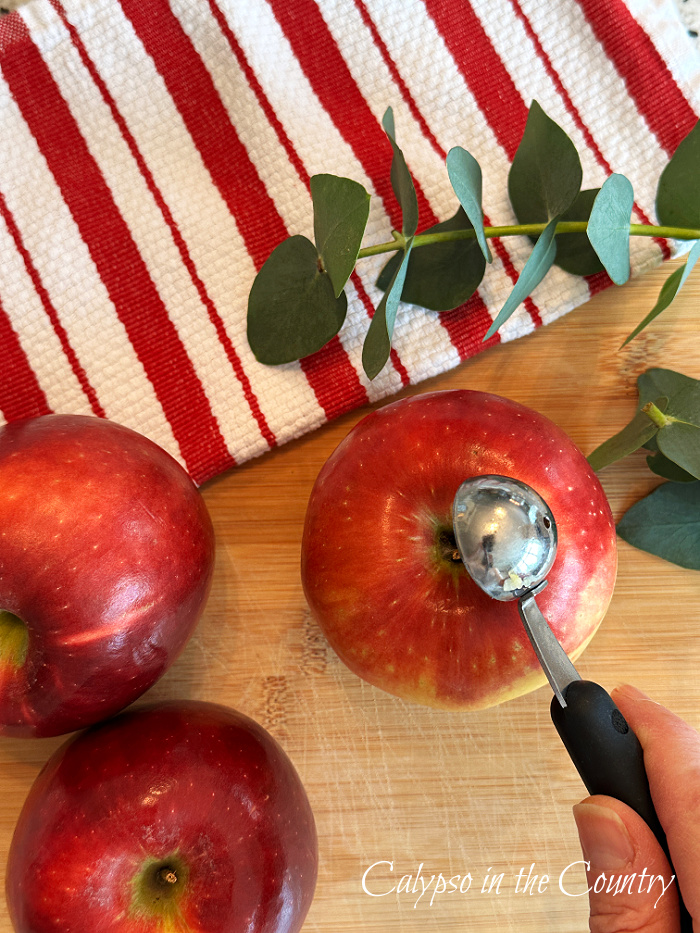 red and white striped towel with three red apples and melon scooper - DIY apple candle holders