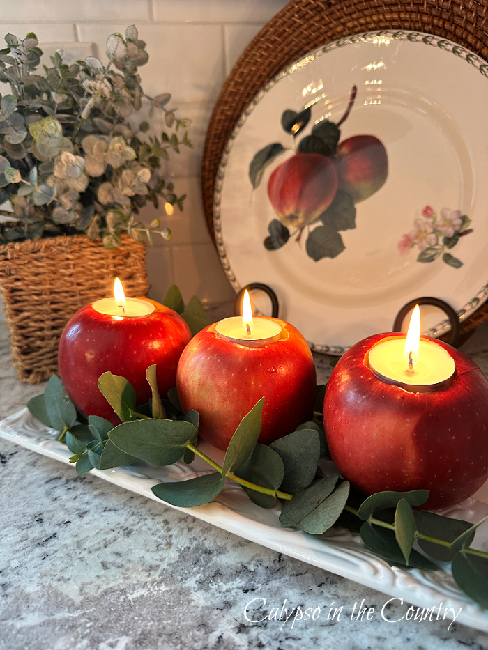 Three apple candles on dish in front of apple plate - DIY apple candle holders