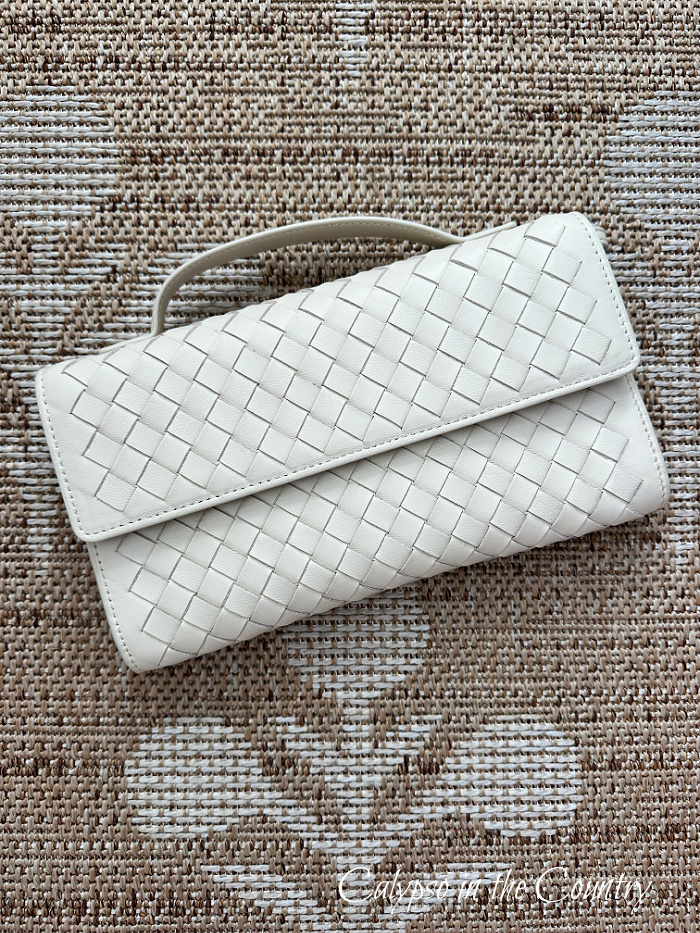 Woven cream handbag on floral seagrass rug