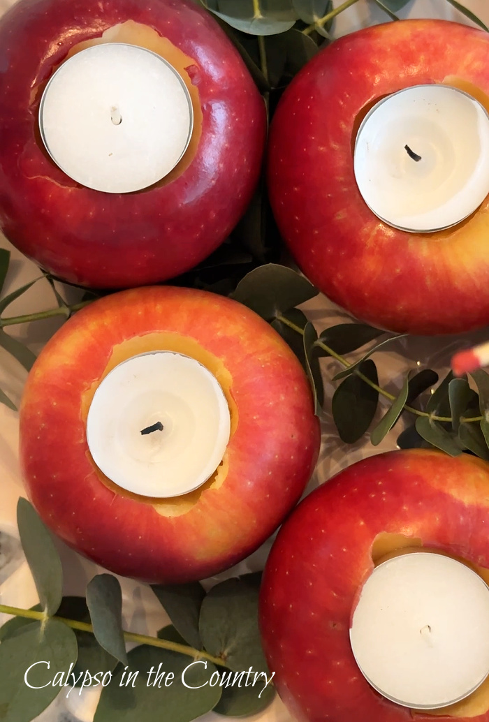 four apples with tea lights with eucalyptus - DIY apple candle holders